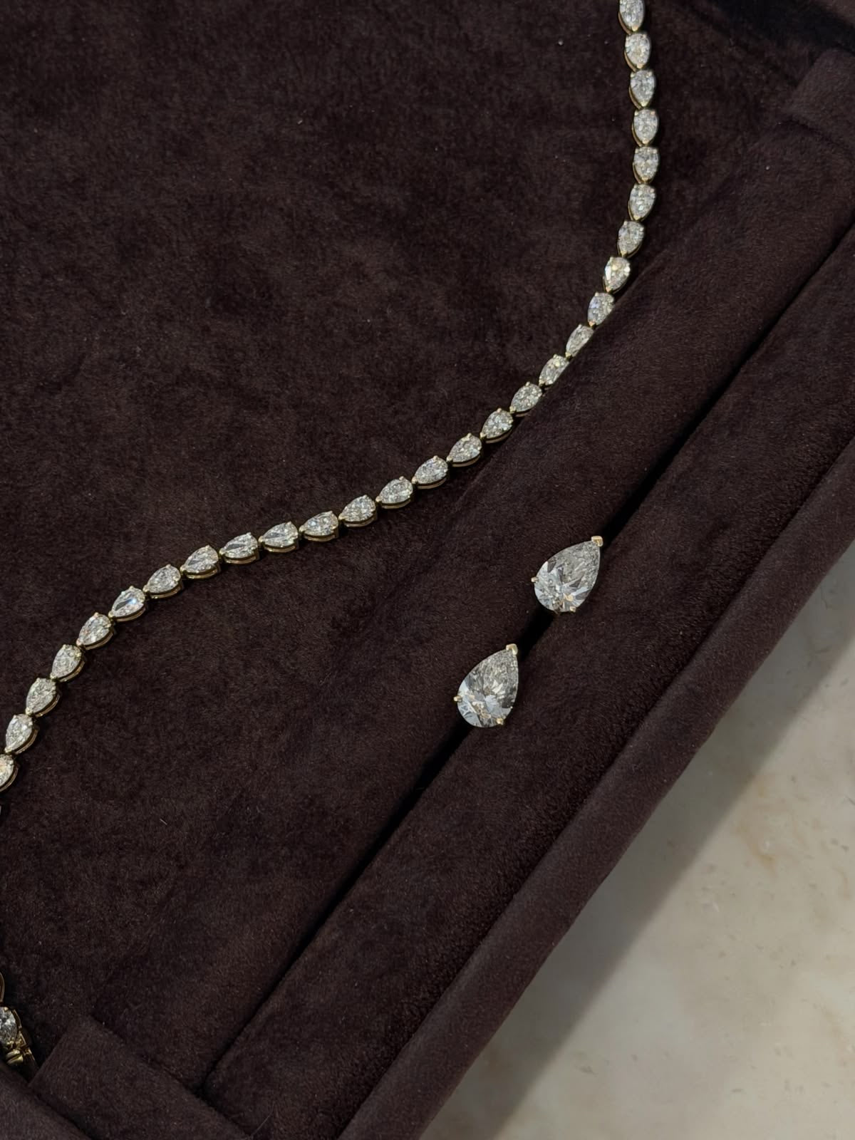 Pear-cut diamond studs on black velvet