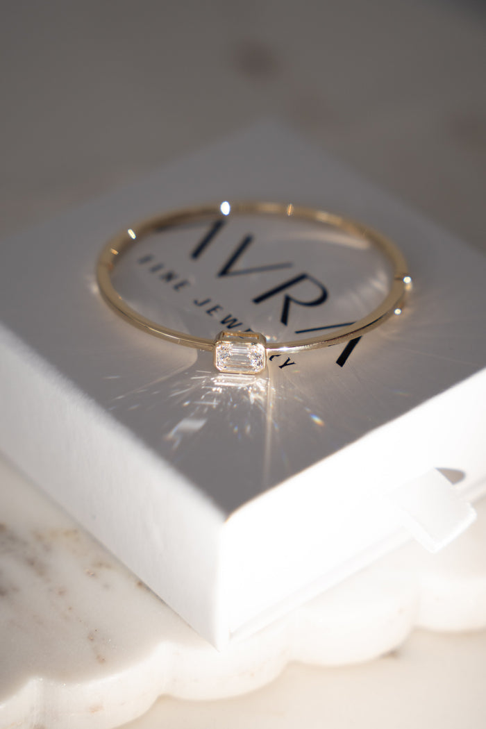 The Emerald Diamond Bangle resting on its AVRA box